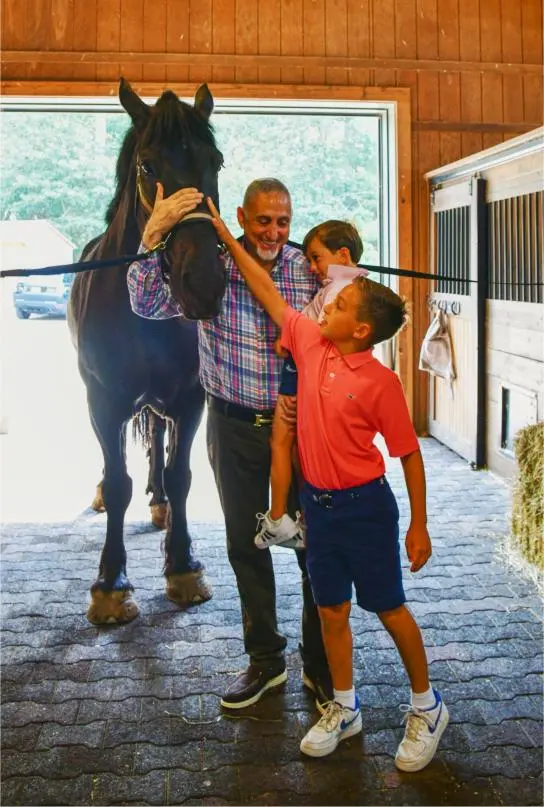 Paul Mihailides bonds with young riders at The Preserve, highlighting the club's top-tier equestrian and family-friendly luxuries.